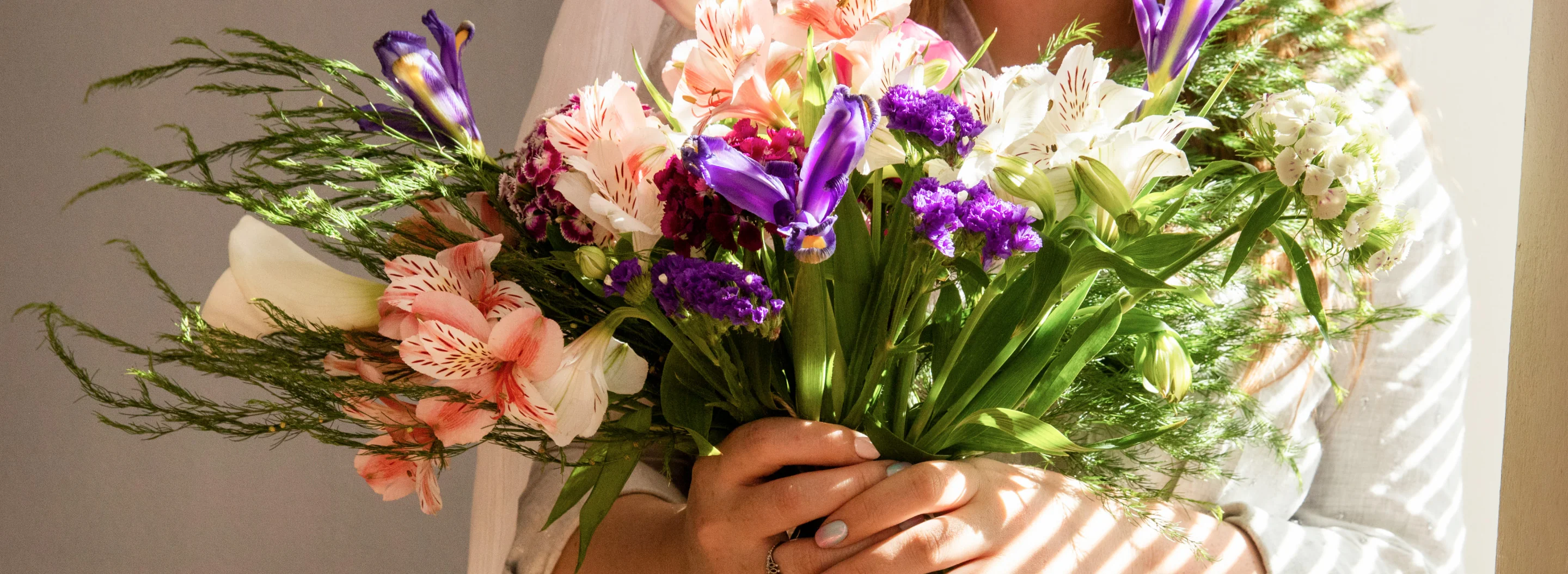 Side view of girl holding bouquet with various spring flowers